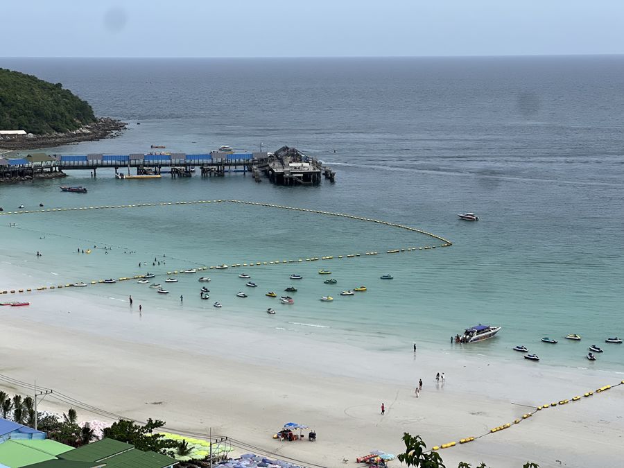 Koh Larn beach with longtail boats and the pier